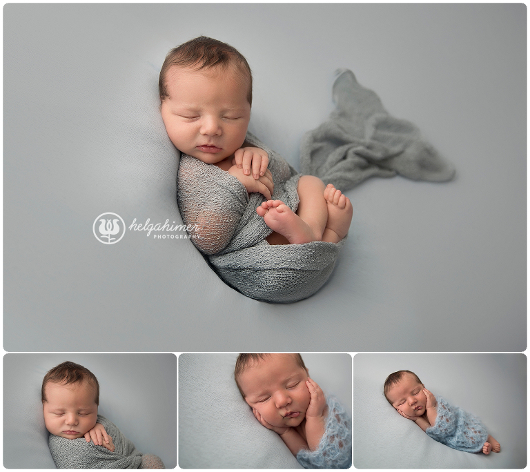 newborn baby wrapped in blue wrap in a studio light setup
