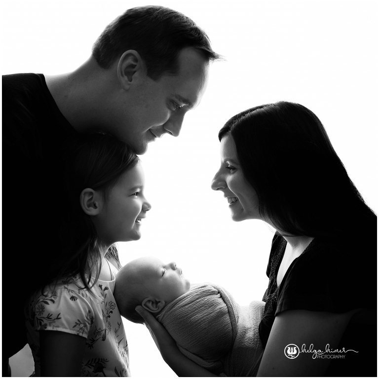 black and white family photo with a 6 weeks old child and a sibling high key light behind the models
